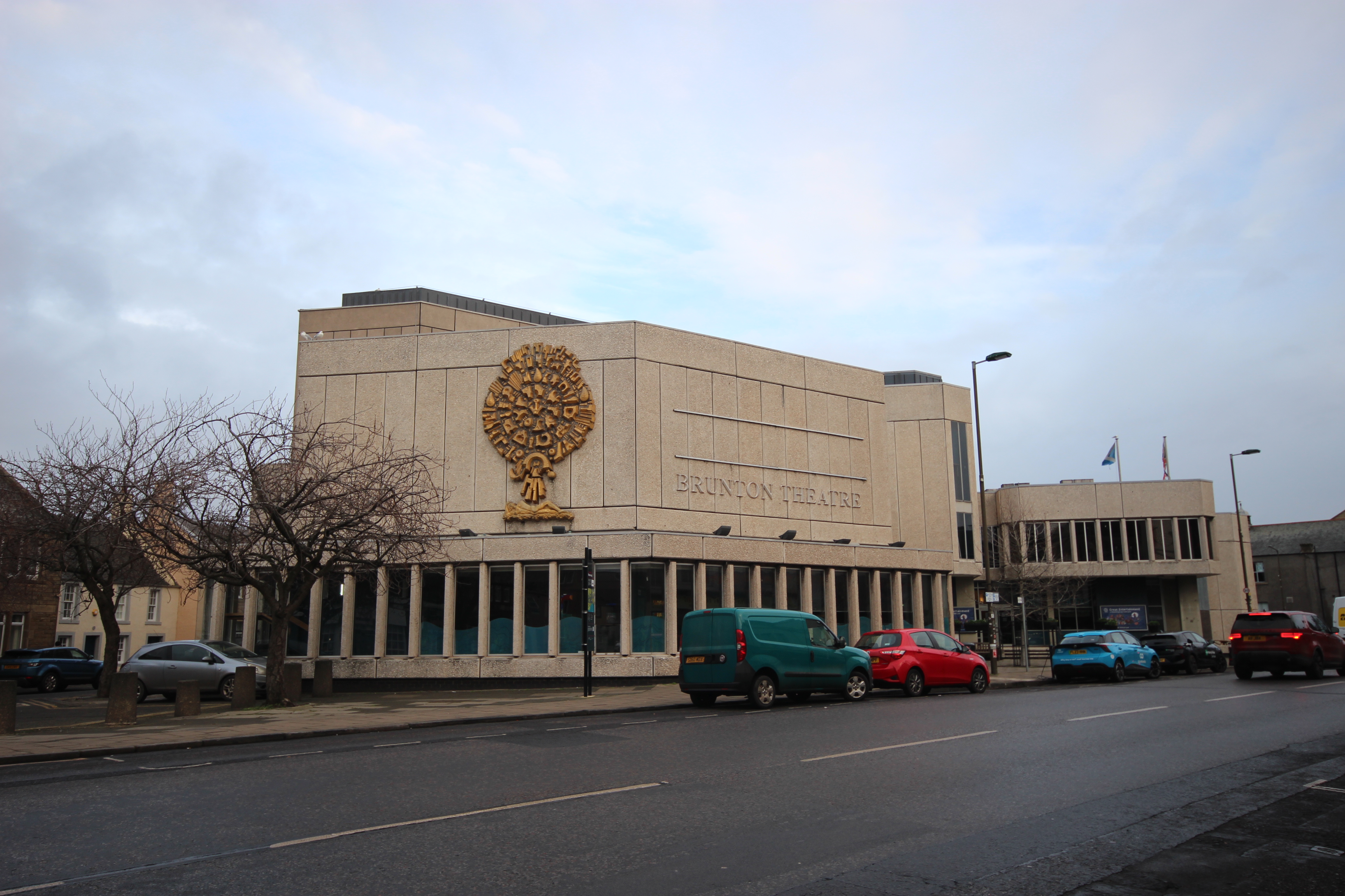 Image of the west and south elevations of the Brunton Hall during the daytime on a cloudy day.