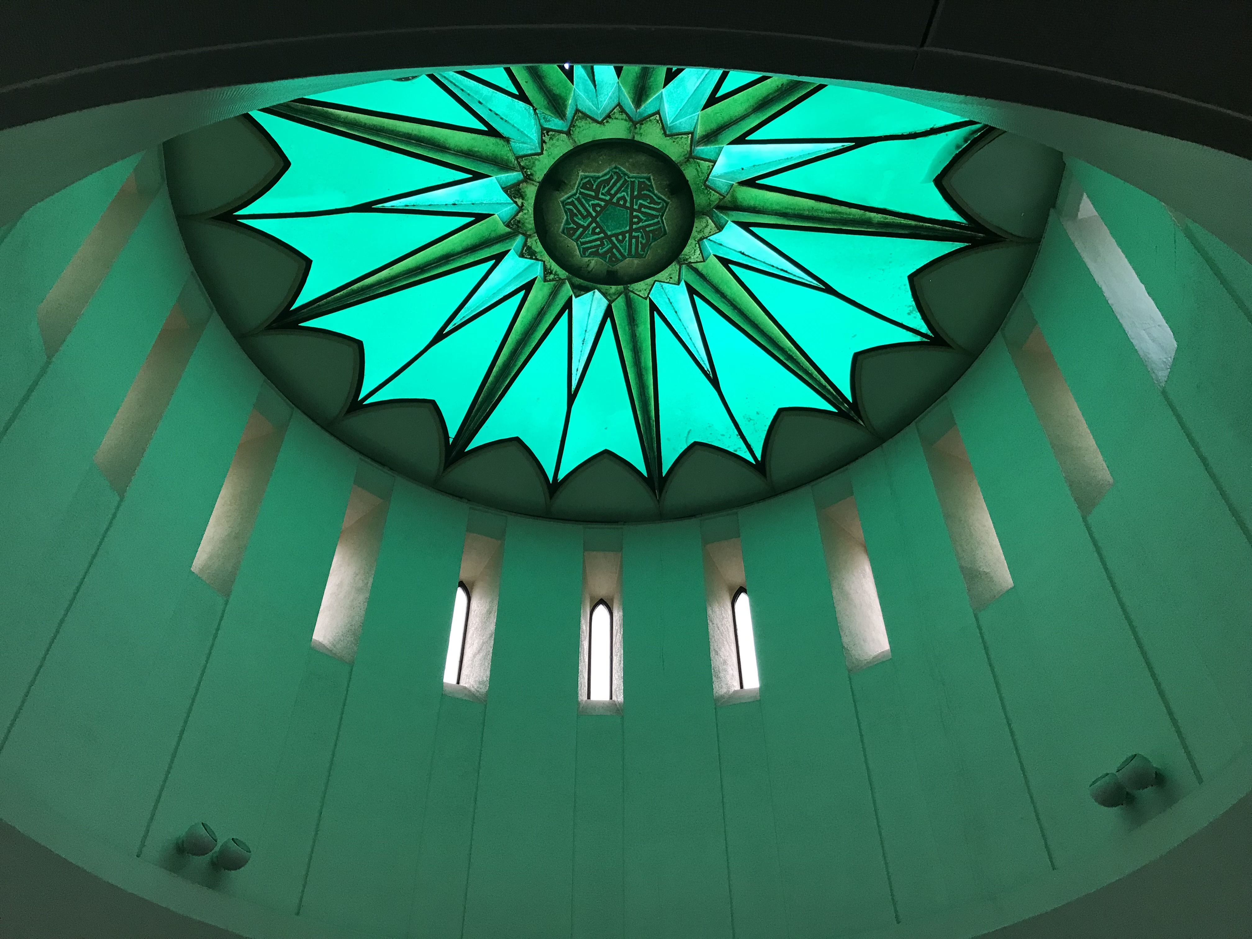 View of interior of the dome of Glasgow Central Mosque with light shining through green patterned glass