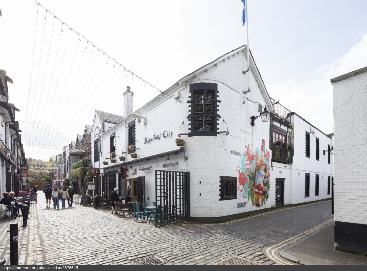 Ubiquitous Chip restaurant on right - white building with black window margins, cobbled street to centre and white sky